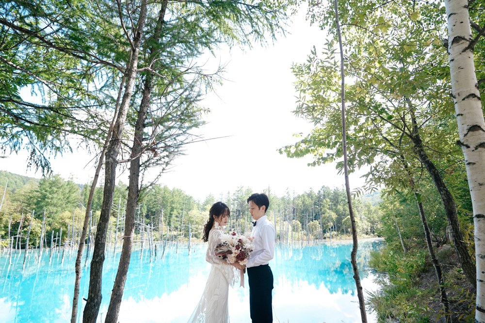 北海道・青い池の前撮り/フォトウェディングのロケーション撮影 | 澄んだ青い色の池をバックに。