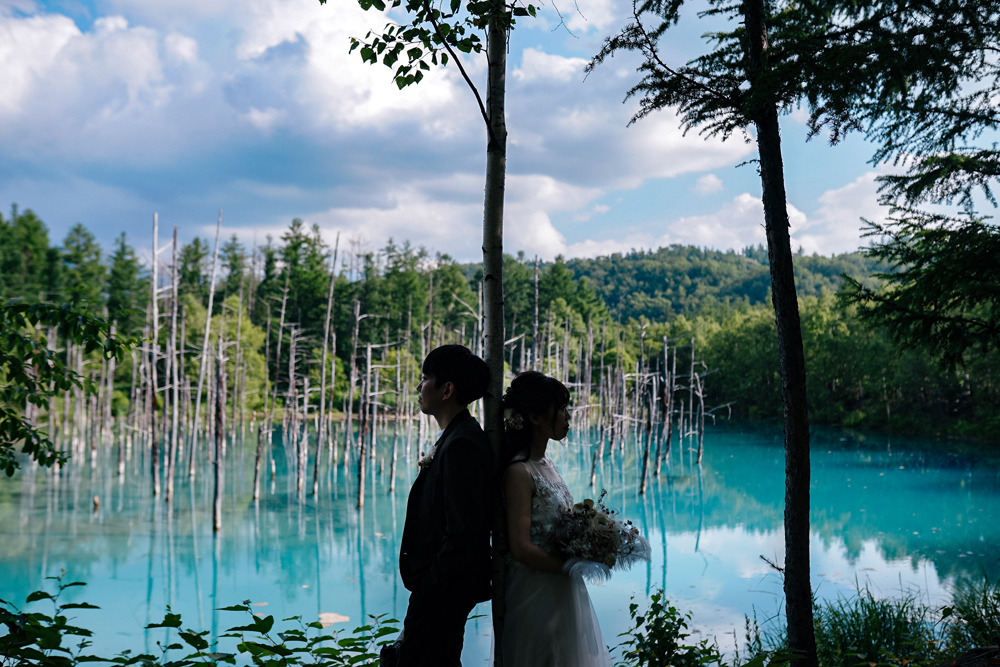 北海道・青い池の前撮り/フォトウェディングのロケーション撮影 | 澄んだ青い池で洋装前撮り。