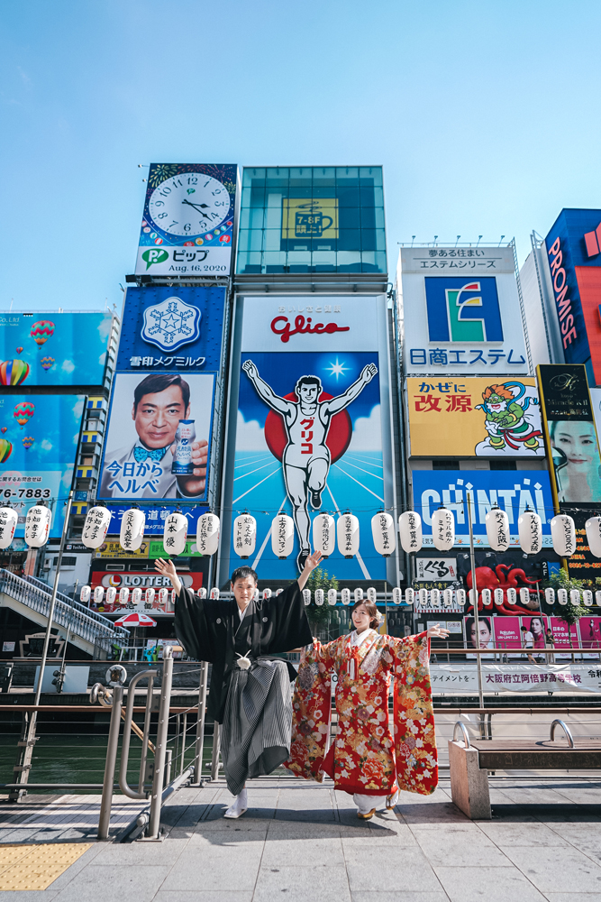 大阪・道頓堀の前撮り/フォトウェディングのロケーション撮影 | 大阪を象徴するグリコと一緒にグリコポーズで前撮りショット。