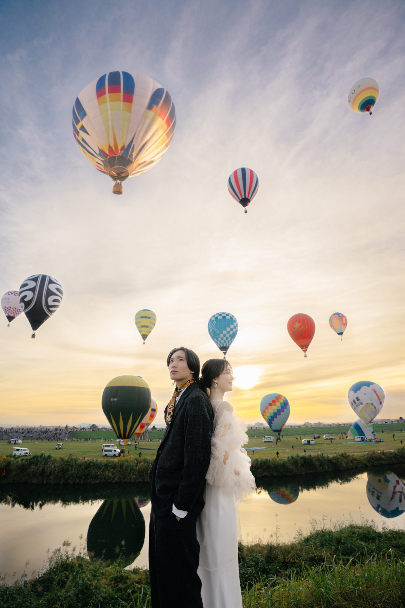 佐賀・佐賀バルーンフェスタの前撮り/フォトウェディングのロケーション撮影 | 日の出とともに離陸する気球が川に鏡面する光景が美しい、佐賀バルーンフェスタのロケーションフォト。