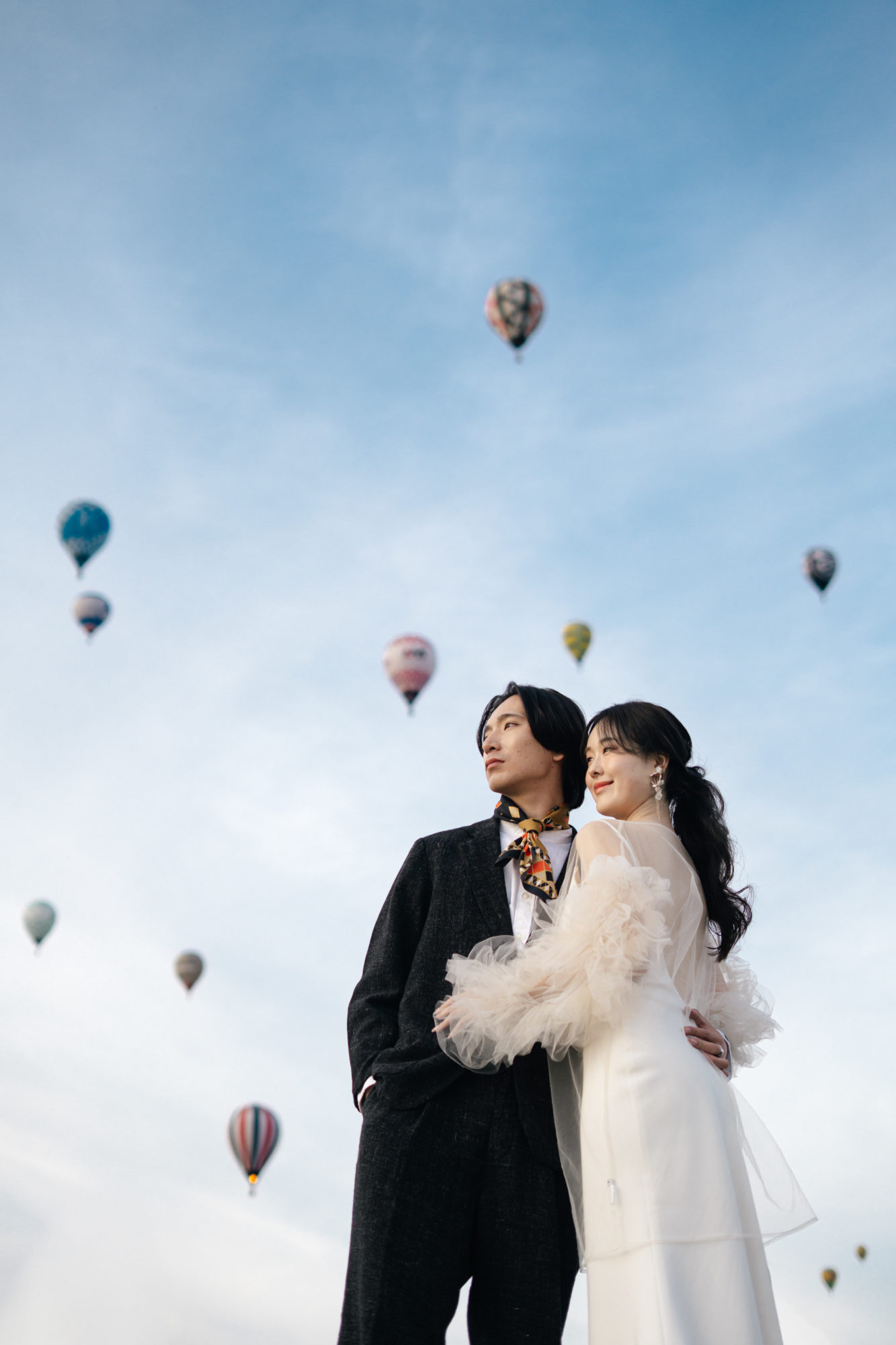 佐賀・佐賀バルーンフェスタの前撮り/フォトウェディングのロケーション撮影 | 次々に離陸するバルーンをバックに。