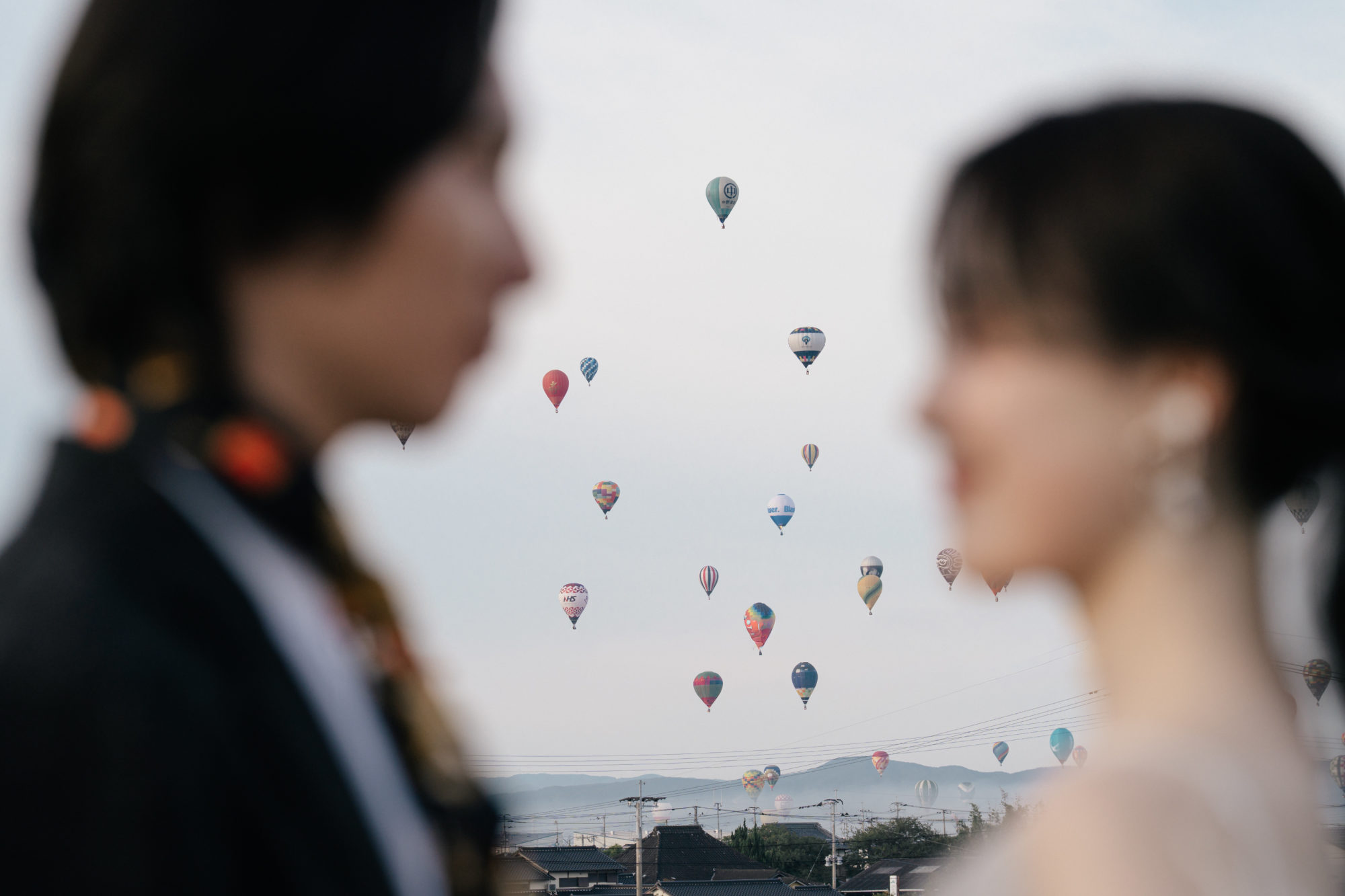 佐賀・佐賀バルーンフェスタの前撮り/フォトウェディングのロケーション撮影 | 離陸した気球たちを背景に。