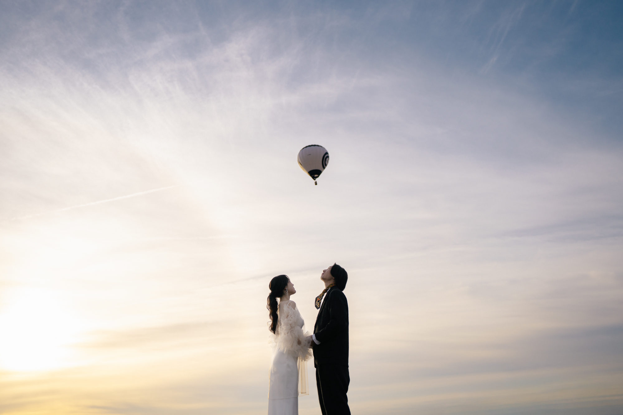 佐賀・佐賀バルーンフェスタの前撮り/フォトウェディングのロケーション撮影 | 朝焼けの中に気球が画になる前撮り。